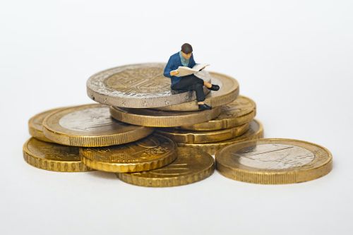 A little human figure sitting on hard money